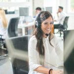 Image of a woman in an offshore office, engaged in a phone call, representing outsourced client service