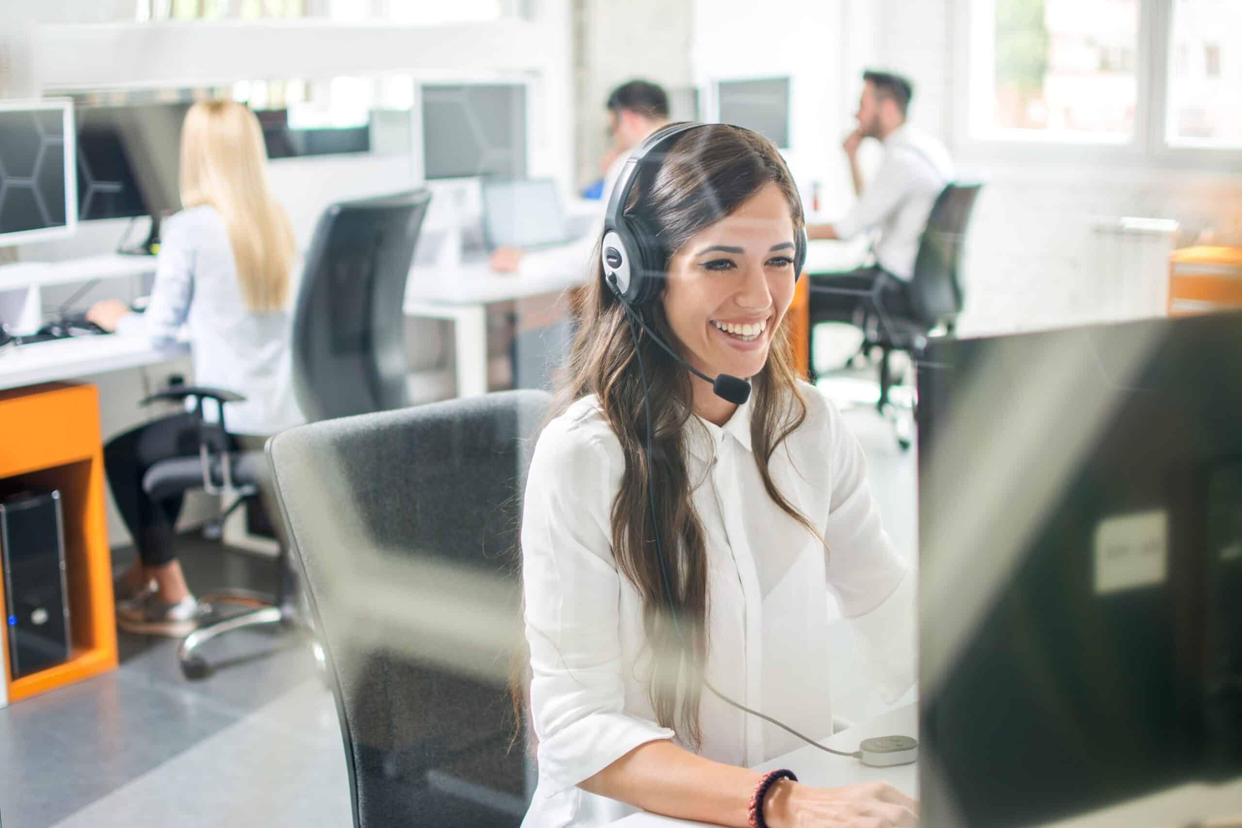 Image of a woman in an offshore office, engaged in a phone call, representing outsourced client service